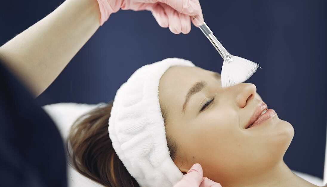 Woman enjoying a relaxing facial treatment at a spa, highlighting skincare and relaxation.