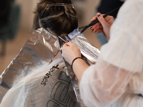 a woman is getting her hair cut by a hair stylist